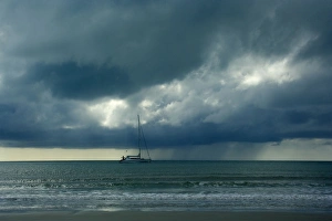 Thunderstorm and boat - tropical thunderstorm is brewing over the ocean at a beach near Thunderstorm and boat - tropical thunderstorm is brewing over the ocean at a beach near