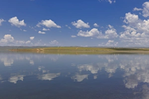 Fluffy clouds in a blue summer sky, reflected in a lake, distant reflected gers, Arkhangai Fluffy clouds in a blue summer sky, reflected in a lake, distant reflected gers, Arkhangai