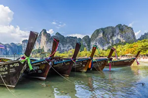 Long tail boats and karst scenery on Railay beach in Railay, Ao Nang, Krabi Province Long tail boats and karst scenery on Railay beach in Railay, Ao Nang, Krabi Province