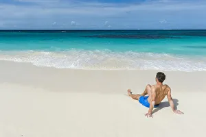 Man relaxing on the world class Shoal Bay East beach, Anguilla, British Oversea territory Man relaxing on the world class Shoal Bay East beach, Anguilla, British Oversea territory