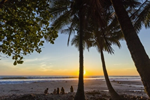 People by palm trees at sunset on Playa Hermosa beach, far south of the Nicoya Peninsula People by palm trees at sunset on Playa Hermosa beach, far south of the Nicoya Peninsula