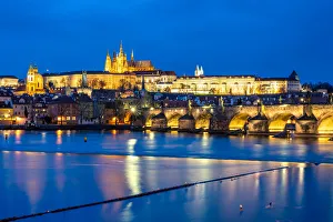 St. Vitus Cathedral and Prague Castle lit up during the evening blue hour reflecting St. Vitus Cathedral and Prague Castle lit up during the evening blue hour reflecting