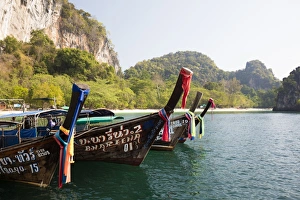 Traditional longtail boats and limestone cliffs, Hong Island, one of the Koh Hong Islands Traditional longtail boats and limestone cliffs, Hong Island, one of the Koh Hong Islands