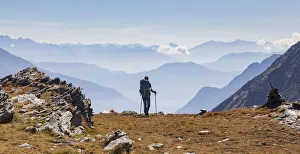 Hiker looking to the mountainscape and mountain profiles in background in Swiss Alps Hiker looking to the mountainscape and mountain profiles in background in Swiss Alps