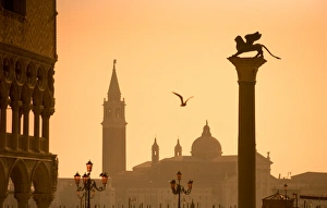 Italy, Veneto, Venice; The Palazzo dei Dogi, the bacino di San Marco with a sculpture of the lion of Venice and San Giorgio Maggiore in Italy, Veneto, Venice; The Palazzo dei Dogi, the bacino di San Marco with a sculpture of the lion of Venice and San Giorgio Maggiore in