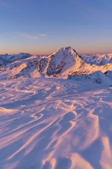 Sunrise light to Gavia pass mountains from a snowcapped summit during winter Sunrise light to Gavia pass mountains from a snowcapped summit during winter