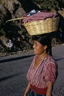 GUATEMALA, Lake Atitlan Indian girl walking along road carrying a basket of washing GUATEMALA, Lake Atitlan Indian girl walking along road carrying a basket of washing