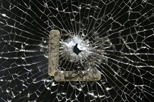 A bullet hole is seen on a cracked window at a gym next to the scene where three police A bullet hole is seen on a cracked window at a gym next to the scene where three police