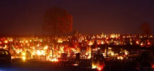 Candles placed at graves are seen during All Saints Day at a cemetery in the village of Candles placed at graves are seen during All Saints Day at a cemetery in the village of