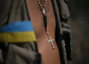 A cross and bullet are seen on Ukrainian serviceman as he stands in his camp near Donetsk A cross and bullet are seen on Ukrainian serviceman as he stands in his camp near Donetsk