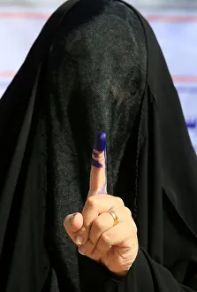 A female security member shows her ink-stained finger after casting her vote at a polling A female security member shows her ink-stained finger after casting her vote at a polling