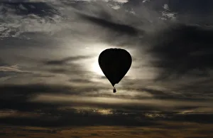 A hot air balloon is silhouetted at sunrise after taking off from Reconciliation Place A hot air balloon is silhouetted at sunrise after taking off from Reconciliation Place