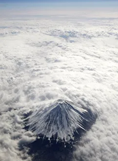 Japans Mount Fuji, covered with snow and surrounded by cloud, is seen from an airplane Japans Mount Fuji, covered with snow and surrounded by cloud, is seen from an airplane