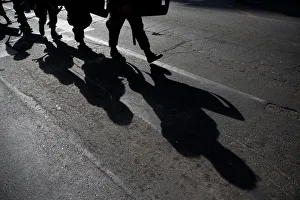 Military policemen cast their shadows as they march toward a protest to mark International Military policemen cast their shadows as they march toward a protest to mark International