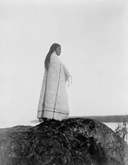 Cowichan woman, full-length portrait, wearing blanket, standing on rock, c1913. Photograph Cowichan woman, full-length portrait, wearing blanket, standing on rock, c1913. Photograph