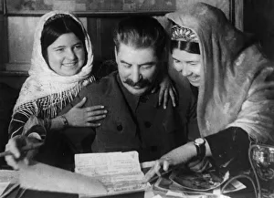 Joseph stalin with two young women from a collective farm in tadjikistan at a conference Joseph stalin with two young women from a collective farm in tadjikistan at a conference