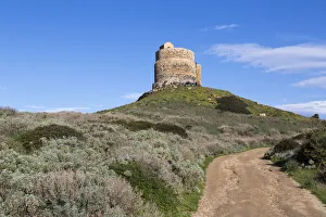Landscape with dirt road leading to San Giovanni di Sinis tower, Oristano, Sardinia, Italy Landscape with dirt road leading to San Giovanni di Sinis tower, Oristano, Sardinia, Italy