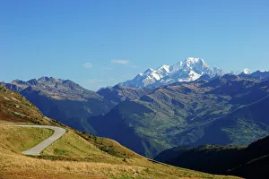 The pass road leading up to Col de la Madeleine, the snow-capped peaks of the Mont Blanc The pass road leading up to Col de la Madeleine, the snow-capped peaks of the Mont Blanc