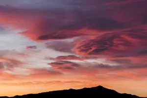 Sunset lights up clouds above mountain ridge in Joshua Tree National Parks southern Sunset lights up clouds above mountain ridge in Joshua Tree National Parks southern