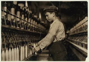 A doffer replaces full bobbins at Globe Cotton Mill, Augusta, Georgia, 1909 (b/w photo) A doffer replaces full bobbins at Globe Cotton Mill, Augusta, Georgia, 1909 (b/w photo)